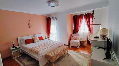 a bedroom with a bed and a television in it at LunaSol in Costa da Caparica