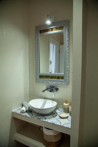 a bathroom with a sink and a mirror at Lalaros Apartment in Glossa