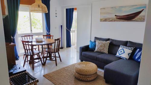 a living room with a couch and a table at LunaSol in Costa da Caparica