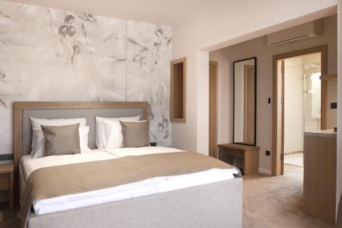 a bedroom with a large bed with a wall at Bracera Inn in Malinska