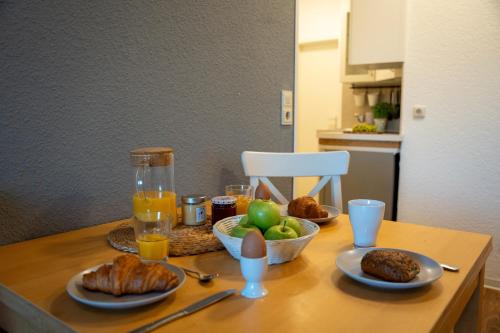 a table with plates of food and fruit on it at Ferienhof Kruse Wohnung Nr 5 in Grömitz