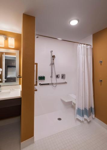 a bathroom with a shower and a toilet and a sink at TownePlace Suites by Marriott Naples in Naples