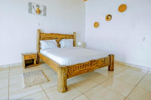 1 dormitorio con cama de madera en una habitación en Kigali Wings Apartment 7 A en Kigali