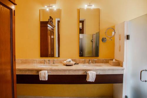 a bathroom with two sinks and a large mirror at Hotel Boutique Casa Don Gustavo, Campeche in Campeche