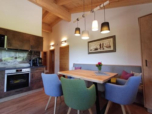 een keuken met een houten tafel en blauwe stoelen bij Apartments Haufhof , Haus im Ennstal bei Schladming in Haus im Ennstal