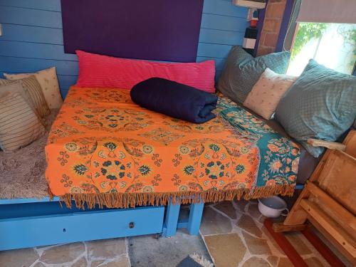 a bed with an orange blanket and pillows on it at Bootshaus in Eisenstadt