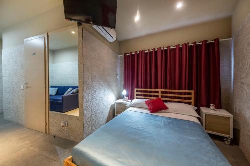 1 dormitorio con cama y cortina roja en Il Giardino di Agata en Mascalucia