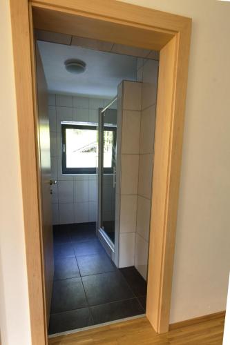 a glass door to a bathroom with a mirror at Haus Johendre in Rennweg