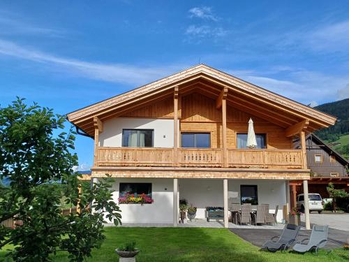 a large wooden house with a balcony at Apartments Haufhof , Haus im Ennstal bei Schladming in Haus im Ennstal