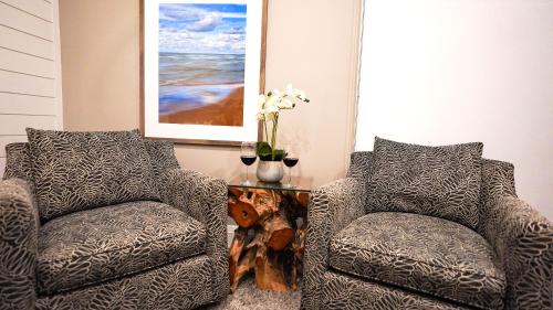 a living room with two chairs and a table at Colonial Hotel & Suites in Grand Bend