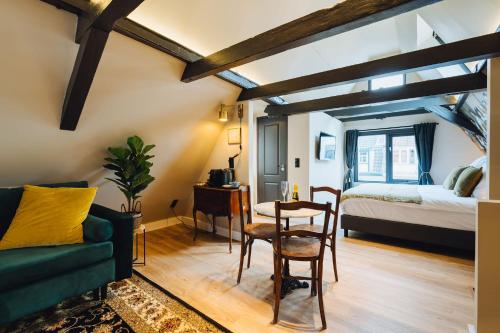a living room with a bed and a table and chairs at Løk Historics luxury art-inspired loft in historic city centre! in Haarlem