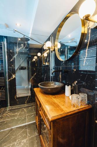 a bathroom with a sink and a mirror at Løk Historics luxury art-inspired loft in historic city centre! in Haarlem