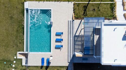 een bovenaanzicht van een zwembad naast een huis bij Villa Azul - Pool, Garden, BBQ in Pefkochori