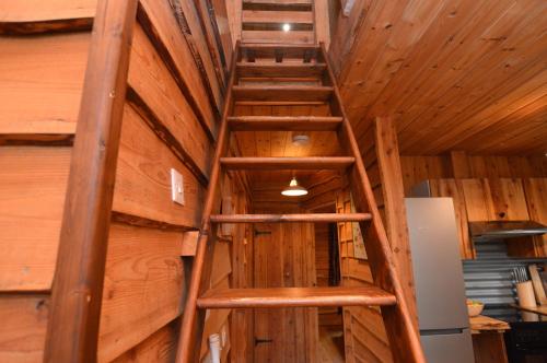 a ladder in the ceiling of a room with wooden walls at Rowan Log Cabin in Dalavich