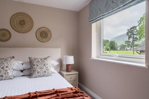 a bedroom with a bed and a large window at Oakbank-Central Grasmere in Grasmere