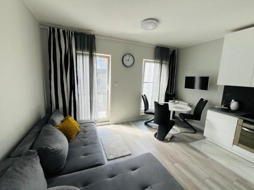 a living room with a couch and a table and a desk at Apartament Studzienna in Elblag