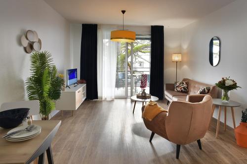 a living room with a couch and a chair at Domitys l'Amarante in Cahors