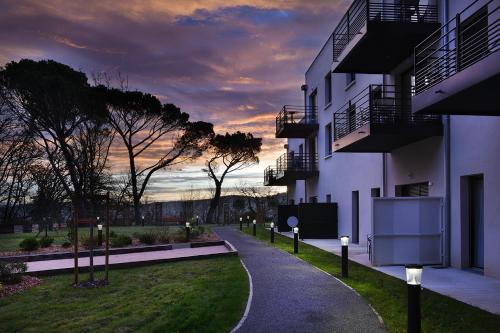 a building with a walkway in front of a building at Domitys l'Amarante in Cahors