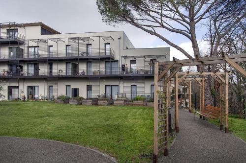 a large white building with a porch and a swing at Domitys l'Amarante in Cahors