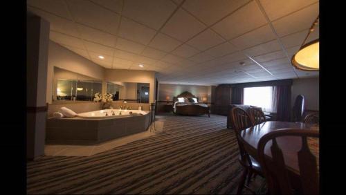 a hotel room with a large tub and a bedroom at Colonial Hotel in Gardner