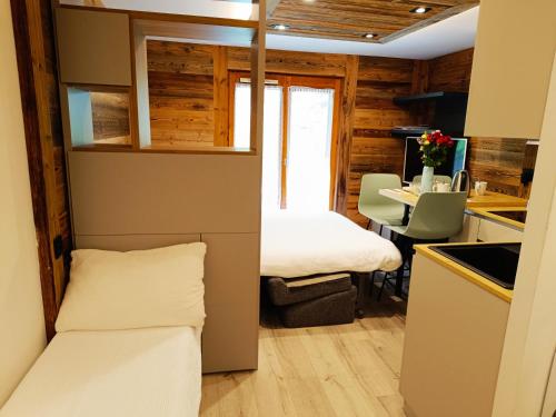 une petite chambre avec un lit et une table dans une cuisine dans l'établissement Le Cocon Des Pistes, à Saint-Gervais-les-Bains