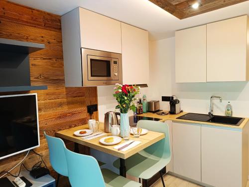 une cuisine avec une table avec des chaises et un micro-ondes dans l'établissement Le Cocon Des Pistes, à Saint-Gervais-les-Bains