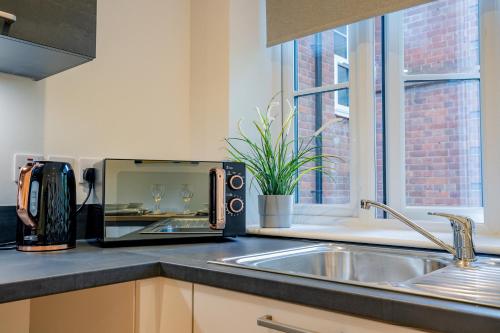 a kitchen with a sink and a toaster on a counter at Guest Homes - Sedlescombe Apartment in Rugby