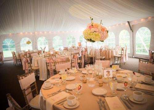 a white tent with tables and chairs and flowers at Colonial Hotel in Gardner