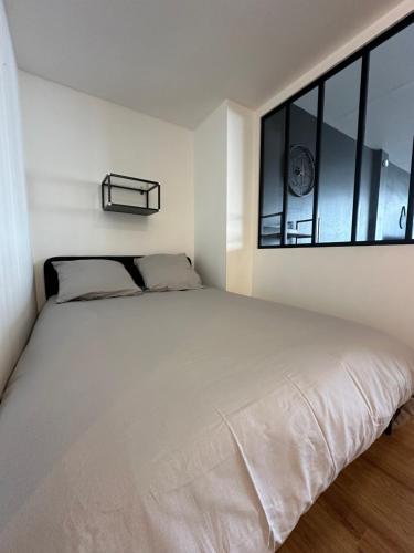 - un lit blanc dans une chambre avec fenêtre dans l'établissement Appartement Citadelle 0, à Dunkerque