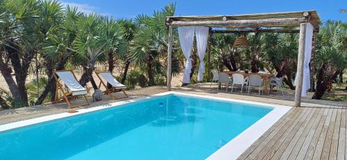 a swimming pool with a gazebo and a table and chairs at Coral Villa - Beachfront Villa with Private Pool by Karula in Inhambane
