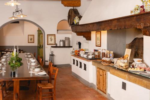 duża kuchnia z długim stołem w restauracji w obiekcie Villa Erbaia Relais de Charme w mieście Barberino di Mugello