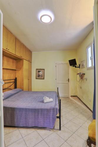 a bedroom with a large bed with a purple blanket at Residence Vacanza Mare in Campo nell'Elba