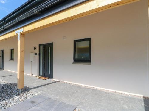 a white building with a wooden roof at Oakbank Mews in Aberfeldy