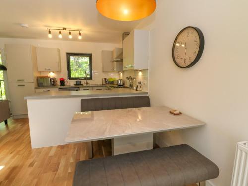 a kitchen with a counter and a clock on the wall at Oakbank Mews in Aberfeldy