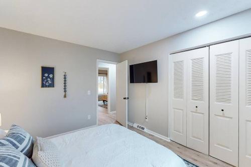 a white bedroom with a bed and a tv at Game Day Getaway-Play Relax Make Memories in Canton