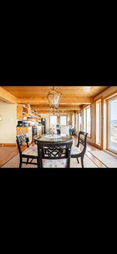 a dining room with a table and chairs in a room at Cabot Trail - Le Château Acadian in Chéticamp