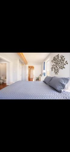 a bedroom with a large bed with a blue blanket at Cabot Trail - Le Château Acadian in Chéticamp