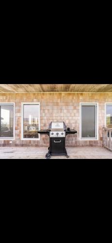 a barbecue grill in front of a brick wall at Cabot Trail - Le Château Acadian in Chéticamp