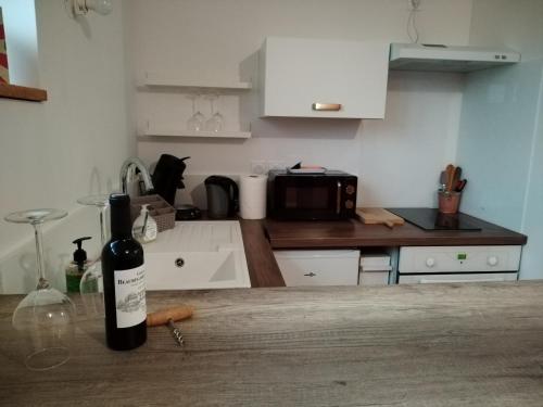- une bouteille de vin assise sur un comptoir dans la cuisine dans l'établissement Le havre de Paix Appartement T2, à Mazères