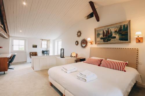 Schlafzimmer mit einem großen weißen Bett und einem Schreibtisch in der Unterkunft Villa Le Passe simple in Saint-Martin-de-Ré