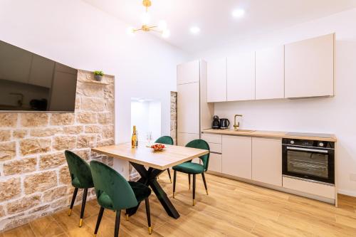 a kitchen with a wooden table and green chairs at Luxury App PALACE OLD TOWN& Studio Green Melody with TERACCE in Split