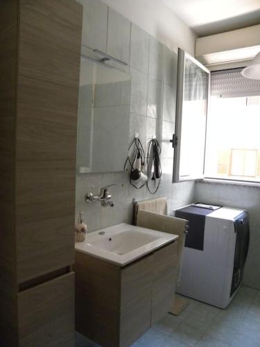 a bathroom with a sink and a refrigerator at Seahorse B&B in Alghero