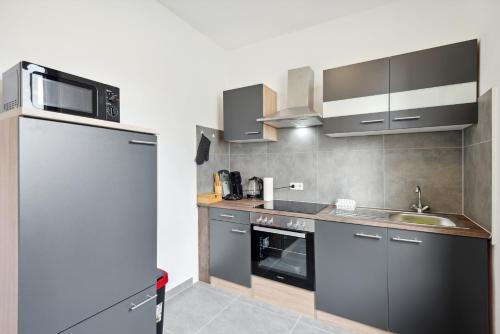 a kitchen with a sink and a microwave at Rheinische Gemütlichkeit, Sali Homes Zentrales Heim in Kleve in Kleve