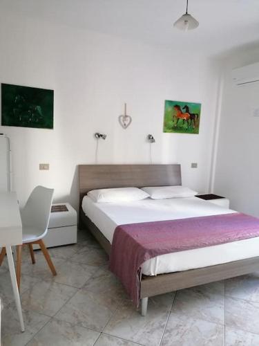 a bedroom with a bed and a table and a chair at Seahorse B&B in Alghero