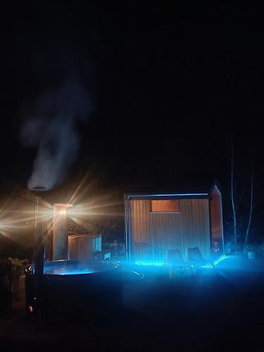 a small building with blue lights in the dark at Sosnowy Gaj in Sławutowo