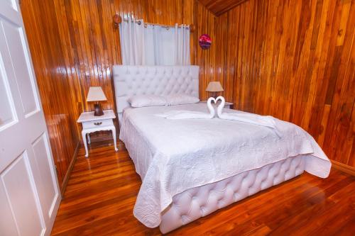 a bedroom with a white bed with two swans on it at Casa Gaia in Monteverde Costa Rica