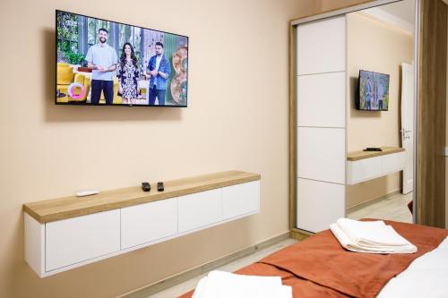 a bedroom with a tv on the wall at Holiday Village Tarcau in Tarcău-Gheuca