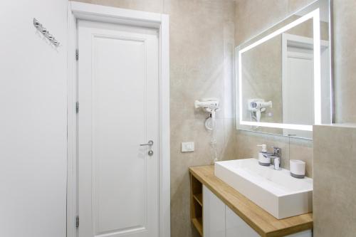 a bathroom with a sink and a mirror at Holiday Village Tarcau in Tarcău-Gheuca