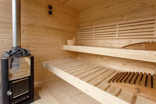 a wooden sauna with a wood stove in it at Holiday Village Tarcau in Tarcău-Gheuca