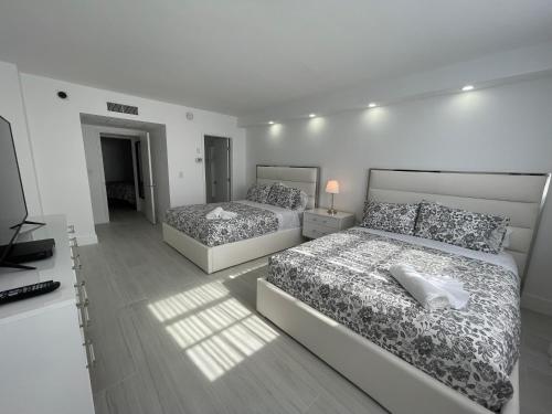 una camera da letto con due letti e una televisione di Amazing Ocean View! 10 floor Parking included a Sunny Isles Beach